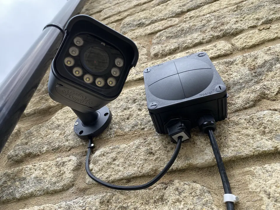 A security camera installed beside a weatherproof connection box