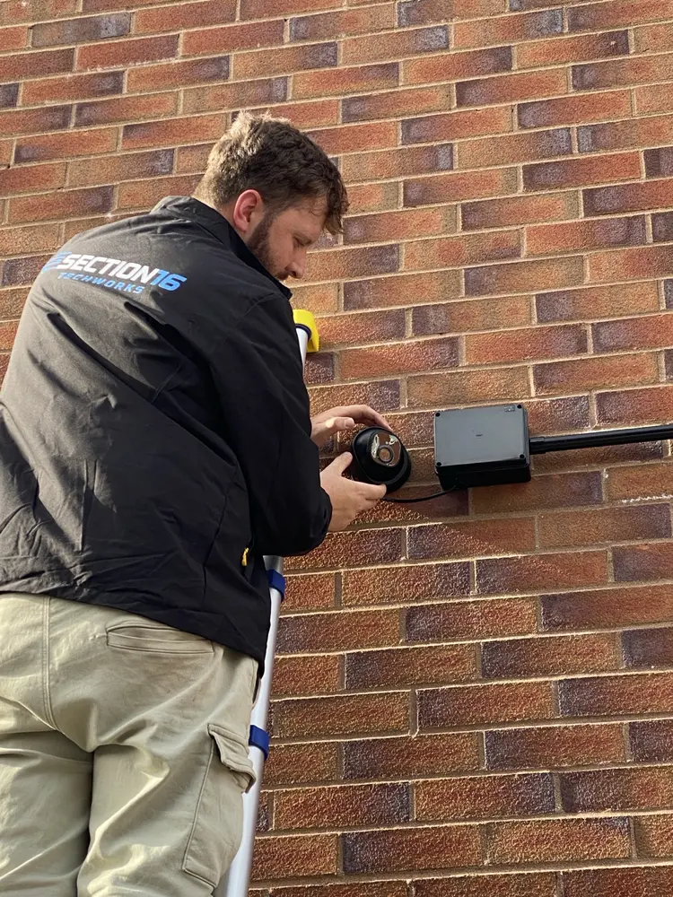 Ollie from Section 16 Techworks installing a security camera